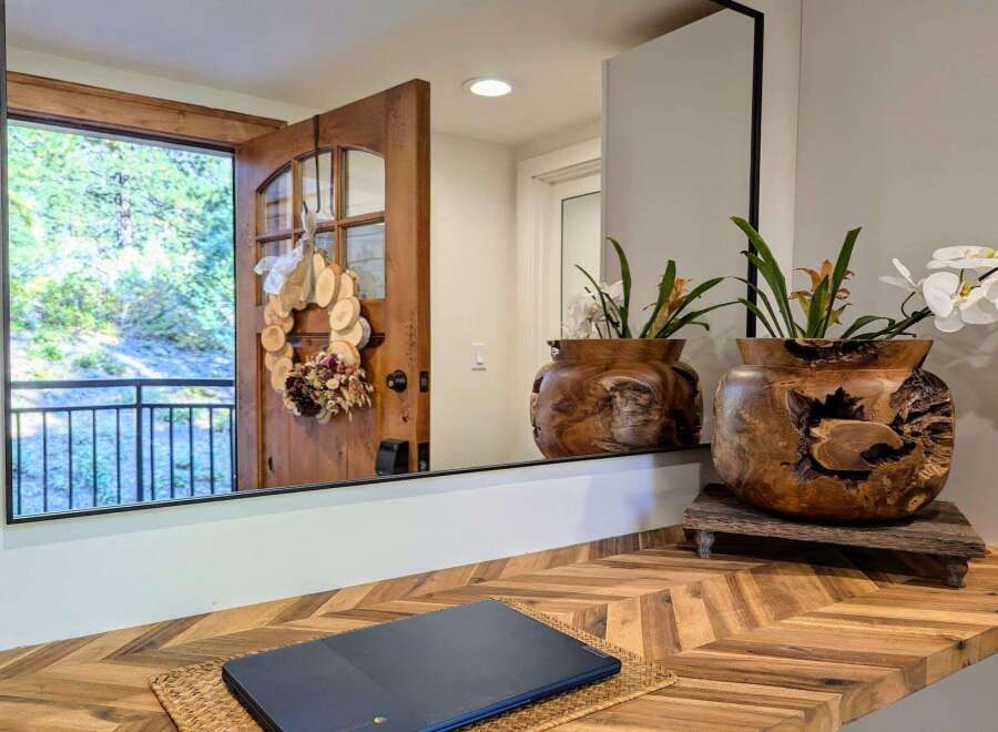 Welcome guests with a charming entryway featuring a rustic wooden door adorned with a unique wood slice wreath.