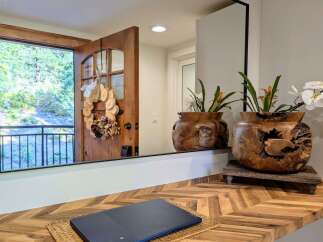 Welcome guests with a charming entryway featuring a rustic wooden door adorned with a unique wood slice wreath.
