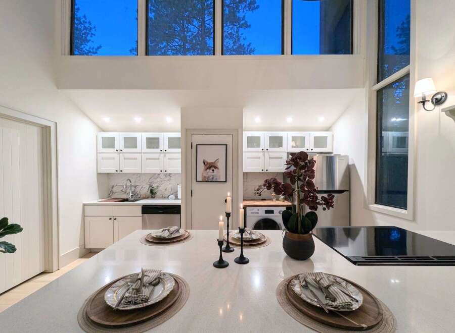 Experience modern living in this stunning kitchen featuring sleek white cabinetry, marble countertops, and a spacious island perfect for entertaining.