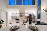 Experience modern living in this stunning kitchen featuring sleek white cabinetry, marble countertops, and a spacious island perfect for entertaining.