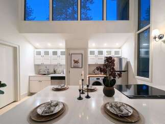 Experience modern living in this stunning kitchen featuring sleek white cabinetry, marble countertops, and a spacious island perfect for entertaining.