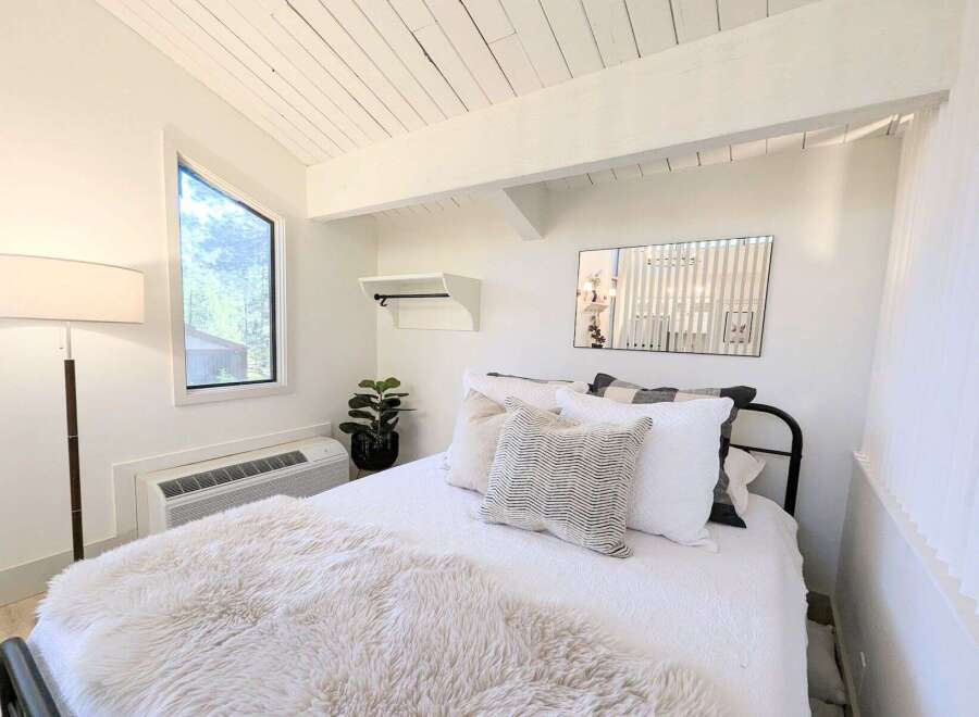 Experience cozy living in this charming bedroom featuring a unique angular window that floods the space with natural light.