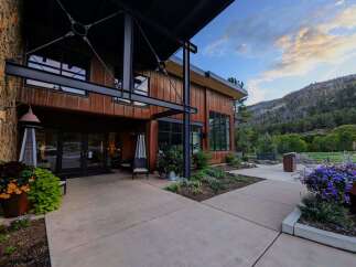 Experience the perfect blend of rustic charm and modern design at this stunning property, featuring a striking stone and wood exterior complemented by expansive windows.