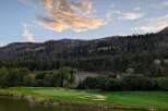 Experience the breathtaking beauty of this golf course nestled against a majestic mountain backdrop.