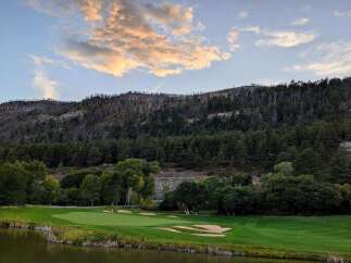 Experience the breathtaking beauty of this golf course nestled against a majestic mountain backdrop.