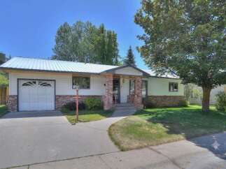 Discover this charming single-story home featuring a durable metal roof and a welcoming brick-accented entrance.
