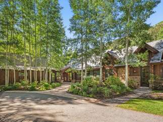 Nestled amidst a grove of aspen trees, this stunning mountain home offers a serene retreat.