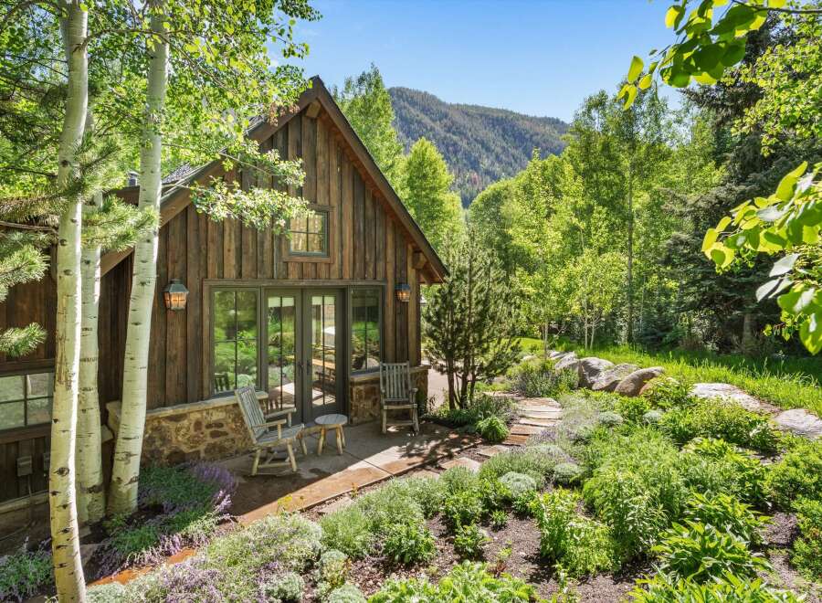 Nestled amidst lush greenery and mature trees, this charming rustic cabin offers a serene mountain retreat.