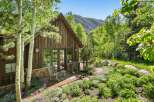 Nestled amidst lush greenery and mature trees, this charming rustic cabin offers a serene mountain retreat.