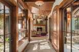 Step into a grand entryway featuring rich wood accents and a stunning stone fireplace.