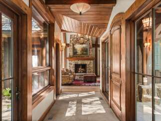 Step into a grand entryway featuring rich wood accents and a stunning stone fireplace.