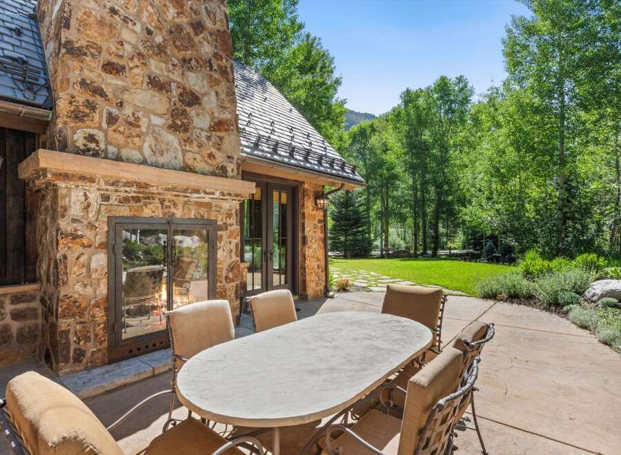 Enjoy al fresco dining on this charming patio, complete with a large stone fireplace perfect for cool evenings.