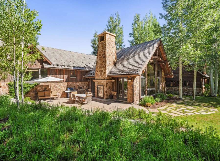 Experience luxurious mountain living in this stunning home, featuring a grand stone fireplace and expansive windows that bring the outdoors in.