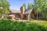 Experience luxurious mountain living in this stunning home, featuring a grand stone fireplace and expansive windows that bring the outdoors in.