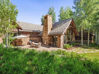 Experience luxurious mountain living in this stunning home, featuring a grand stone fireplace and expansive windows that bring the outdoors in.
