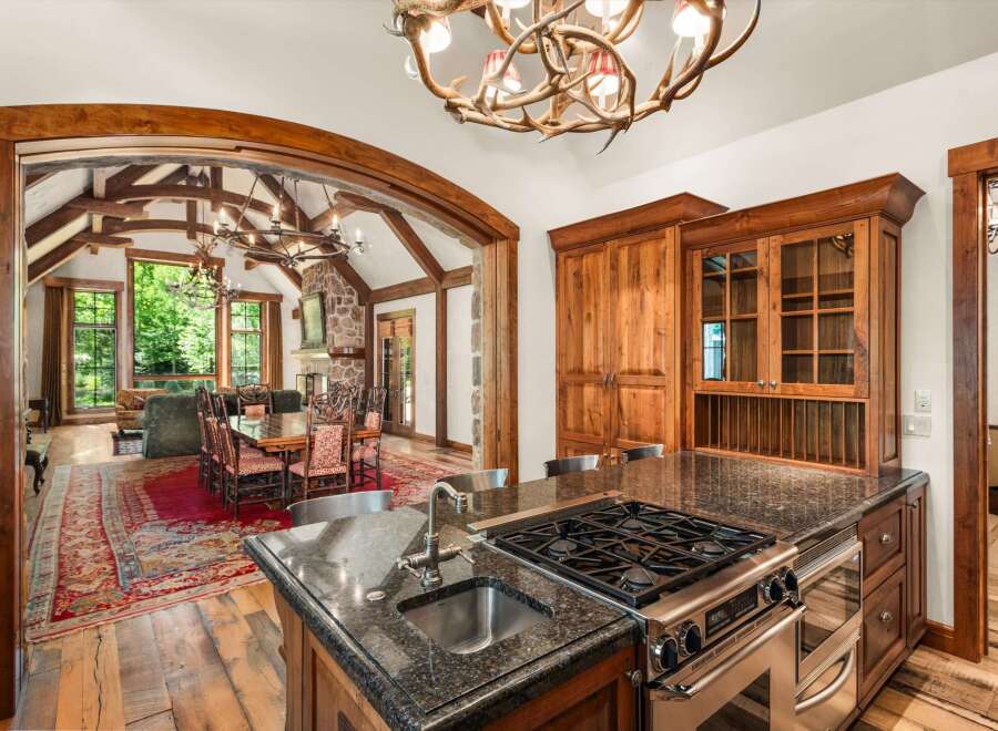 Experience rustic luxury in this stunning mountain home, featuring a gourmet kitchen with a granite island and professional-grade appliances.