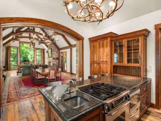 Experience rustic luxury in this stunning mountain home, featuring a gourmet kitchen with a granite island and professional-grade appliances.