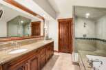 Experience luxury in this stunning bathroom featuring a spacious double vanity with granite countertops and elegant wooden cabinetry.