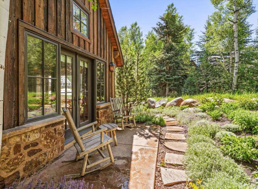 Experience rustic charm with this inviting cabin exterior, featuring natural wood siding and a stone foundation.