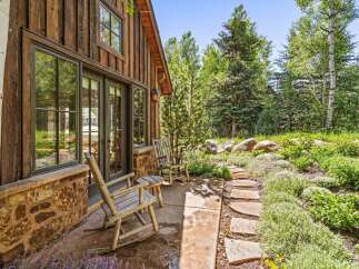 Experience rustic charm with this inviting cabin exterior, featuring natural wood siding and a stone foundation.