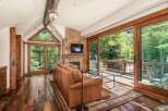 Experience rustic luxury in this stunning living room, featuring a natural stone fireplace and a large leather sofa perfect for cozy evenings.