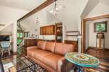 Experience rustic charm in this spacious living area featuring exposed wooden beams and a vaulted ceiling.