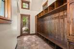 Step into this charming mudroom featuring a rustic wooden bench with ample storage cubbies and a wall of hooks for coats and accessories.