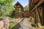 Experience rustic charm in this mountain retreat, featuring a stunning multi-story wood-paneled facade with expansive windows that capture the natural surroundings.