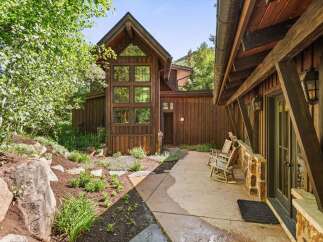 Experience rustic charm in this mountain retreat, featuring a stunning multi-story wood-paneled facade with expansive windows that capture the natural surroundings.