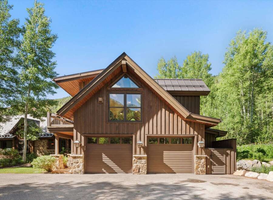 This stunning mountain home features a rustic wood exterior complemented by stone accents and a durable metal roof.