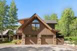 This stunning mountain home features a rustic wood exterior complemented by stone accents and a durable metal roof.