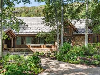 Nestled amidst lush greenery and mature trees, this charming mountain home offers a serene retreat.