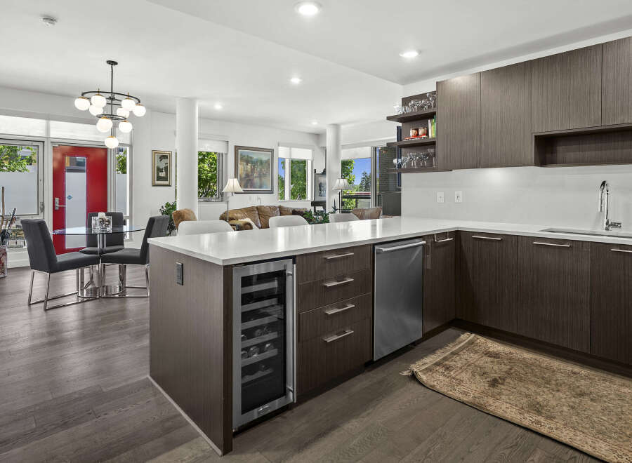 Experience modern living in this stunning open-concept condo, featuring a sleek kitchen with a wine fridge and ample cabinetry.