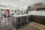 Experience modern living in this stunning open-concept condo, featuring a sleek kitchen with a wine fridge and ample cabinetry.