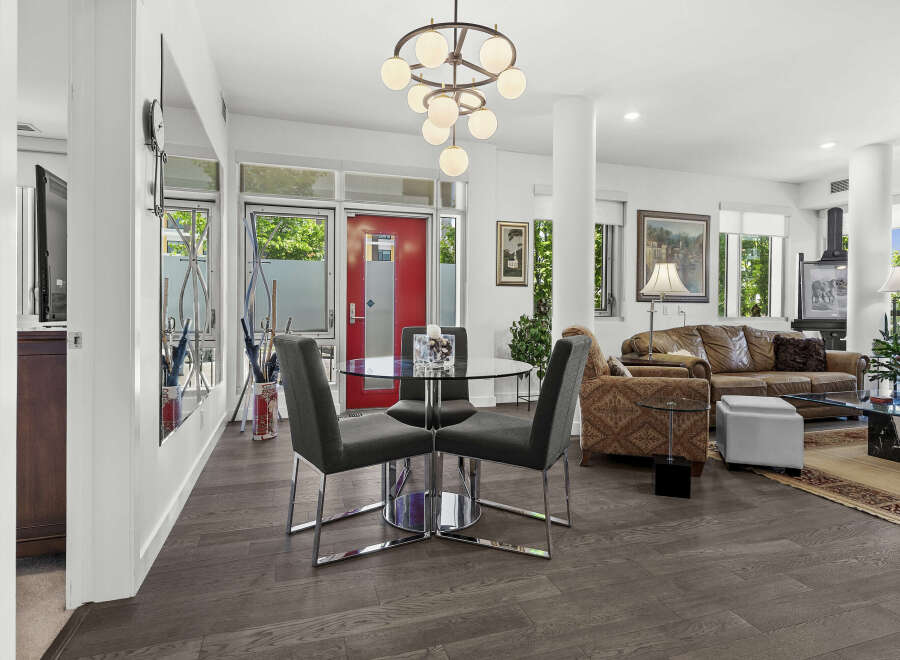 Experience modern living in this spacious open-concept condo, featuring a stylish dining area with a glass-top table and sleek chairs.