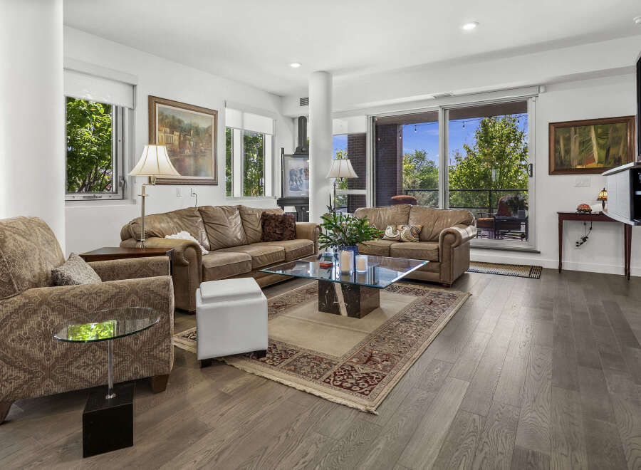 Experience luxurious living in this stunning condo featuring a spacious living area with plush leather sofas and a stylish glass coffee table.