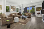 Experience luxurious living in this stunning condo featuring a spacious living area with plush leather sofas and a stylish glass coffee table.