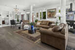 Experience luxurious living in this spacious open-concept home, featuring a beautifully appointed living area with plush leather seating and a striking glass coffee table.