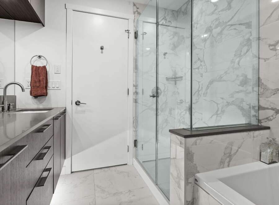 Experience modern luxury in this stunning bathroom, featuring a sleek vanity with ample storage and a sophisticated marble-tiled shower.