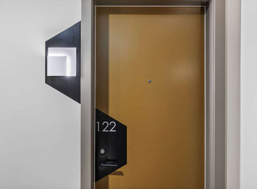 Discover modern living with this stylish apartment door featuring a sleek golden finish and contemporary numbering '122'.