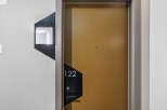 Discover modern living with this stylish apartment door featuring a sleek golden finish and contemporary numbering '122'.