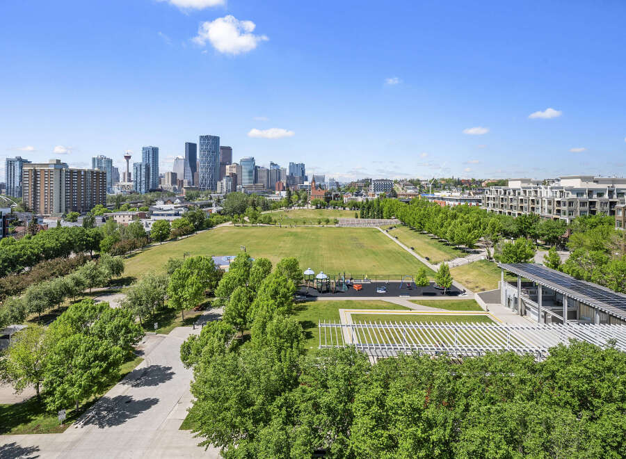 Experience urban living with this stunning panoramic view of the city skyline, featuring modern high-rise buildings and lush green spaces.