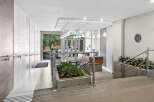 Step into a modern and welcoming lobby featuring a sleek reception desk and elegant pendant lighting.