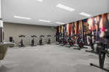 This modern gym features a row of stationary bikes and a rowing machine, perfect for a cardio workout.