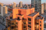 Experience luxury urban living in this stunning high-rise apartment building, bathed in the warm glow of sunset.