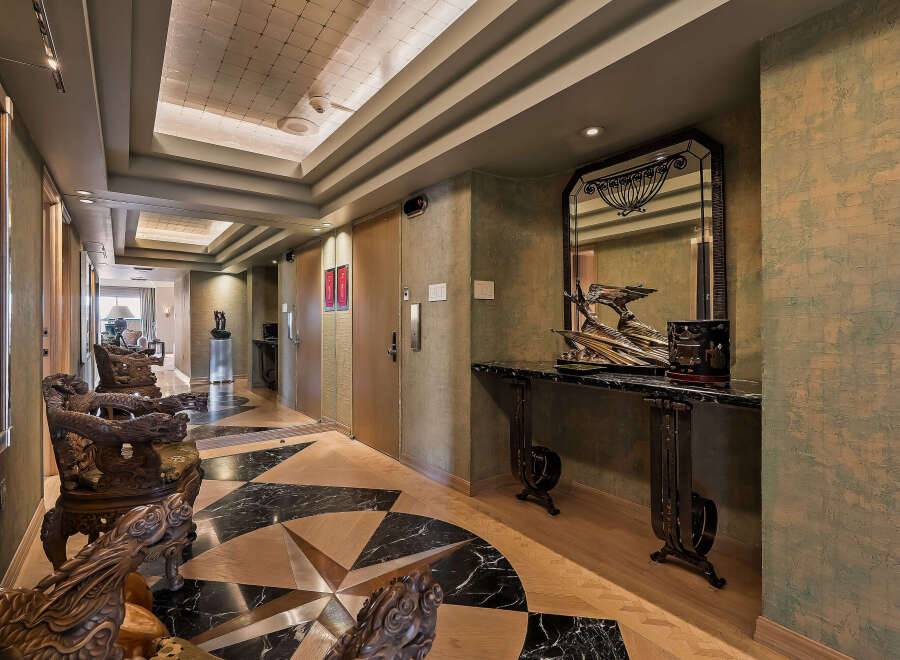 Experience opulent living in this luxurious hallway featuring intricate dragon-carved chairs and a stunning marble console table.