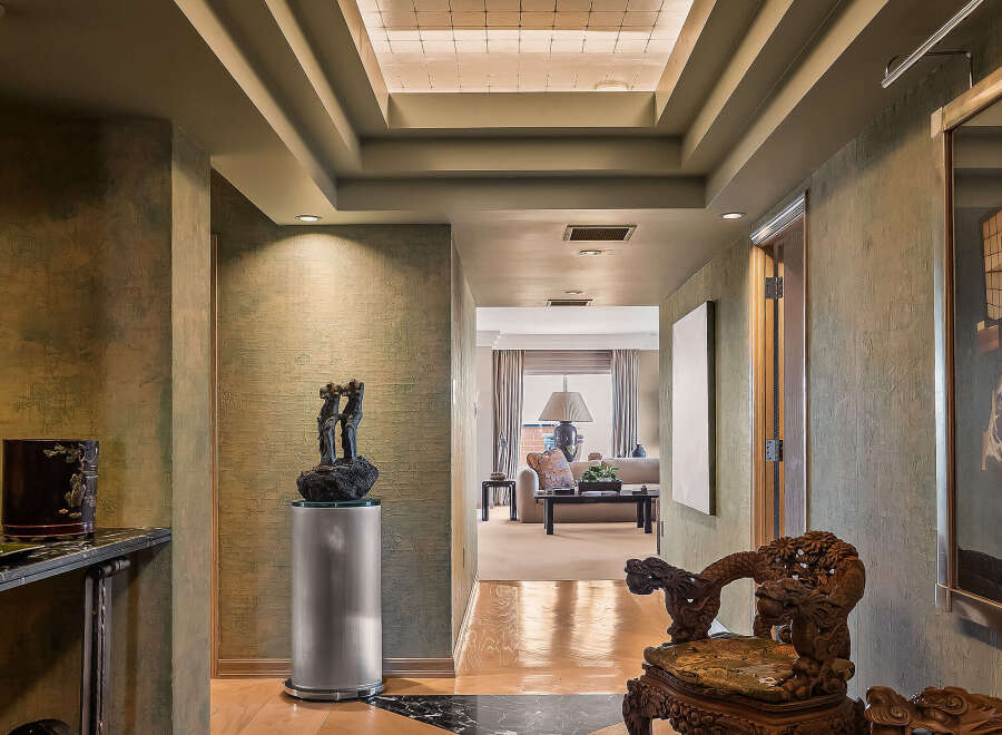Step into this luxurious hallway featuring a stunning geometric marble and wood inlay floor that guides you towards a beautifully appointed living space.