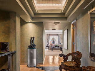 Step into this luxurious hallway featuring a stunning geometric marble and wood inlay floor that guides you towards a beautifully appointed living space.