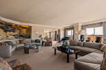 Experience luxurious living in this expansive living room, featuring a grand sectional sofa adorned with decorative pillows and a striking oriental screen.