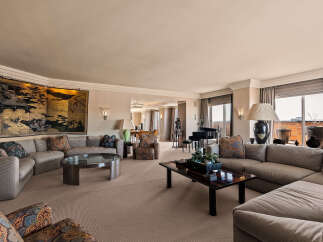 Experience luxurious living in this expansive living room, featuring a grand sectional sofa adorned with decorative pillows and a striking oriental screen.